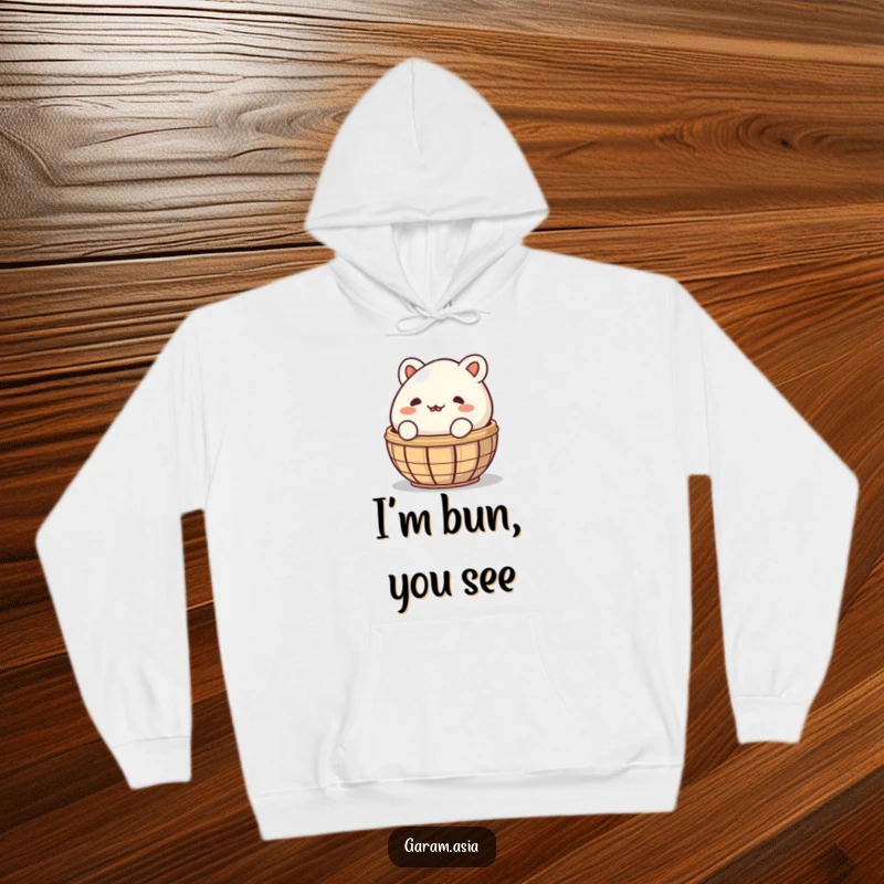 A warm and cozy hoodie featuring a funny bao bun peeking coyly from behind a steaming basket; perfect for comfortable, humorous wear.